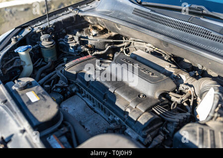 Sporco vano motore nell'Automobile usata, visibili parti del motore, cavi, tubazioni e serbatoi per liquidi. Foto Stock