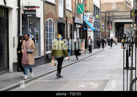 La gente cammina lungo Rivington Street passando accanto alle boutique a febbraio Shoreditch East London UK KATHY DEWITT Foto Stock