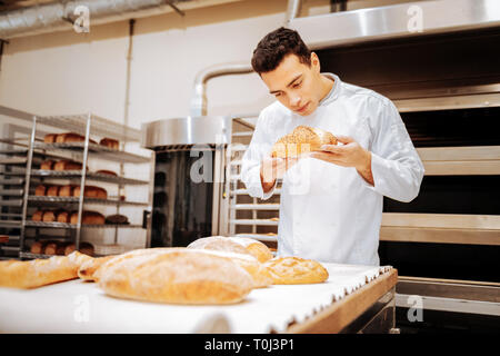 Baker in piedi vicino a tabella per controllare la qualità del pane Foto Stock