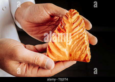 Baker azienda piccola e bella bun con ricotta all'interno Foto Stock