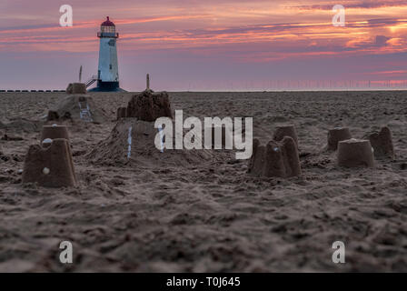 Il Sandcastles On la spiaggia, con serata nuvole e punto di Ayr il faro in background, vicino Talacre, Flintshire, Wales, Regno Unito Foto Stock