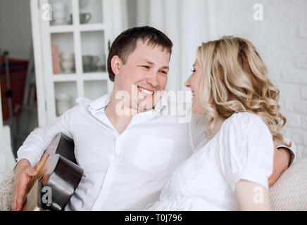 Felice di amare giovane seduto sul lettino Foto Stock