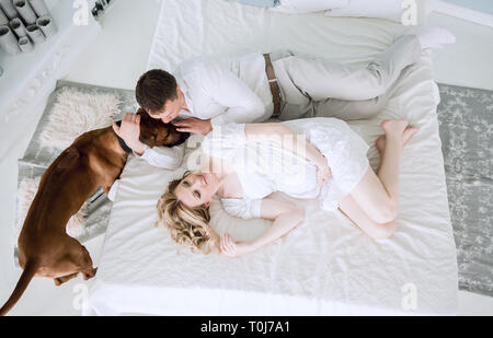 Vista superiore.La famiglia felice in appoggio sul letto Foto Stock