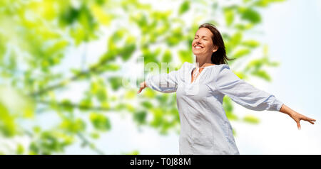 Felice donna sorridente su verde sfondo naturale Foto Stock