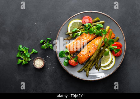 Salmone alla griglia bistecca di pesce, asparagi, pomodoro e insalata di mais sulla piastra. Piatto sano per il pranzo. Vista superiore Foto Stock