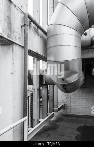 Immagine in bianco e nero di un grande estrattore di metallo sfiato sul tetto di un edificio alto, London, Regno Unito Foto Stock