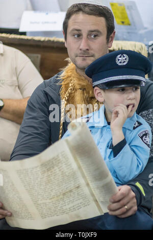 Elkana, Israele. 20 Mar, 2019. La lettura del libro di Ester in una Sinagoga durante la festa ebraica di Purim. In questa vacanza ebrei traditionaly vestito in costumi, leggere la chiocciola di Esther, una storia su un anti-ebraica complotto fallito nell antica Persia e fare un racket ogni volta che il nome di Haman, l'antagonista principale, è menzionato. Credito: Yagil Henkin/Alamy Live News Foto Stock