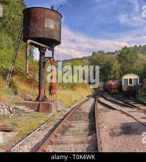 L'età del vapore, carrozze d'epoca e water tower in Dean Forest linea ferroviaria nel Gloucestershire, Inghilterra Foto Stock