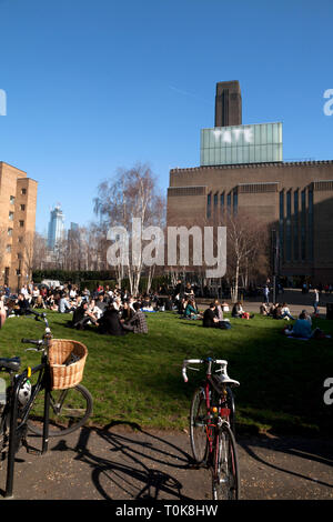 La gente seduta su erba otside tate modern bankside southwark Londra Inghilterra Foto Stock