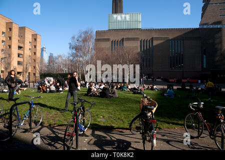 La gente seduta su erba otside tate modern bankside southwark Londra Inghilterra Foto Stock