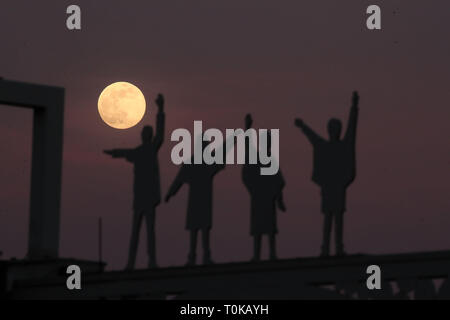 La luna sorge alle spalle di sagome dei Beatles, dal film Aiuto, su Penny Lane in Liverpool. Foto Stock