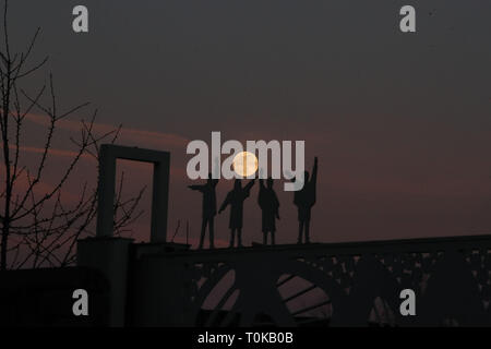 La luna sorge alle spalle di sagome dei Beatles, dal film Aiuto, su Penny Lane in Liverpool. Foto Stock