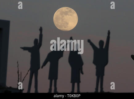 La luna sorge alle spalle di sagome dei Beatles, dal film Aiuto, su Penny Lane in Liverpool. Foto Stock