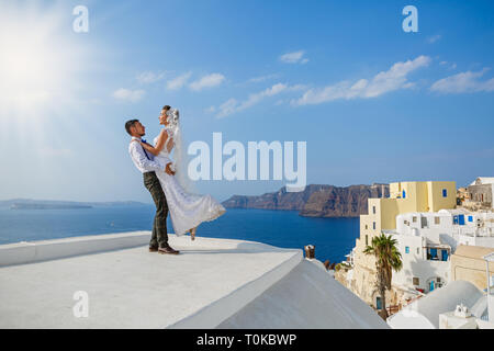 Bella sposi sullo sfondo del mare e l'isola di Santorini Foto Stock