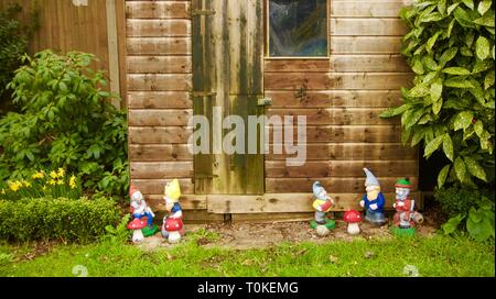 Tettoia da giardino con vecchio giardino gnomi linee fino al di fuori Foto Stock