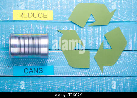 Concetto di riciclo che mostra recylce verde logo con le lattine su un blu sullo sfondo a spiovente e ridurre Foto Stock