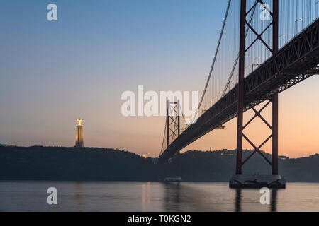 Il Ponte 25 de Abril in Lisbona, Cristo Rei statua, tramonto, Portogallo Foto Stock