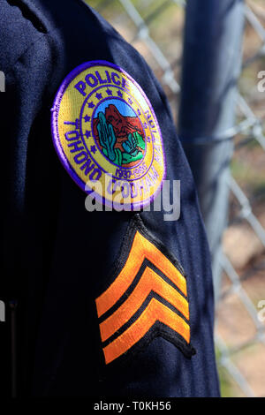 Close up di un nativo americano sergente di polizia delle strisce e Tohono O'Odham indiano prenotazione police badge in Arizona Foto Stock