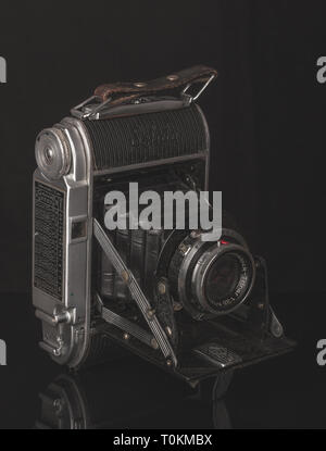 Foto di nostalgico della vecchia telecamera. Una tabella a specchio. Tonalità scure. Foto Stock
