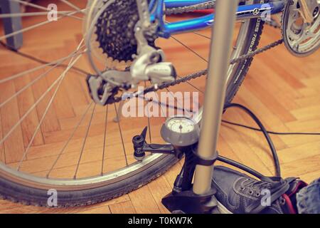 Il gonfiaggio del pneumatico di una bicicletta. Pompaggio di aria all'interno di una ruota di bicicletta. Home manutenzione della bicicletta. Servizio biciclette e mantenendo per la nuova stagione Foto Stock