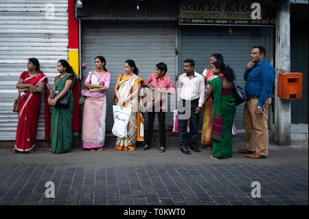 La mattina presto pendolari in attesa del loro tragitto, Colombo, Sri Lanka Foto Stock