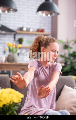 Infastiditi curly donna essendo gonfiato dal bouquet di fiori Foto Stock