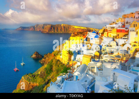 La cittadina di Oia sull isola di Santorini, Grecia. Tradizionale e famose case e chiese con le cupole blu sulla Caldera, il Mare Egeo Foto Stock