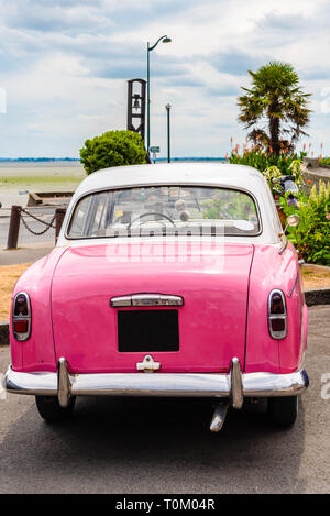 Un classico rosa oldtimer auto parcheggiate sulla costa a Cancale, Bretagna Francia Foto Stock