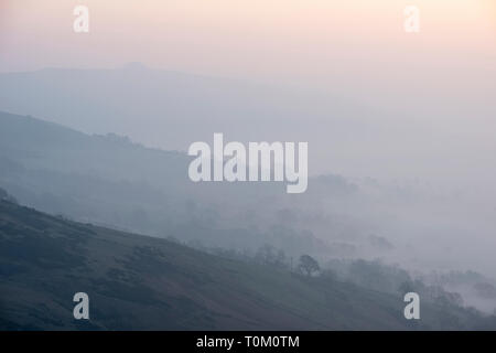 Bellissima alba invernale immagine di panorama di grande rilievo in Peak District in Inghilterra con nebbia appeso intorno ai picchi Foto Stock