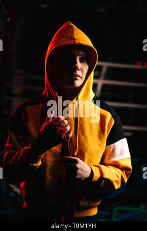 Donna sportive boxer nel cofano tira bende rosse sulle mani . Foto Stock