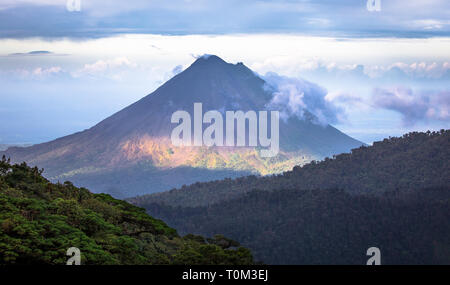 Volcan Arenal domina il paesaggio durante il tramonto visto da Monteverde, Costa Rica. Foto Stock