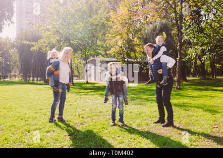 Tema famiglia svago attivo al di fuori in natura. grande famiglia caucasica con quattro figli. Mamma e papà attivamente rilassante. Goditi la vita nel parco vicino a casa Foto Stock