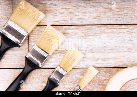 Set di strumenti di pittore su un bianco tavolato in legno, direttamente al di sopra. Copia dello spazio per il tuo testo. Foto Stock