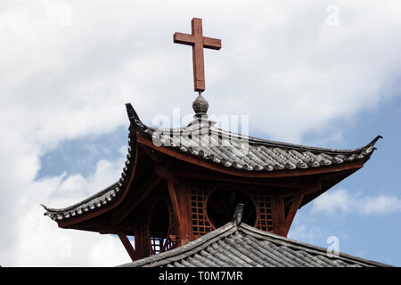 Croce sulla cima di una architettura tradizionale chiesa nella provincia di Yunnan in Cina Foto Stock