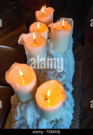 Cluster meraviglioso della bella chiesa di vecchio stile candele appollaiato sulla cima di un grande mucchio di vecchi fuso cera di candela colature Foto Stock