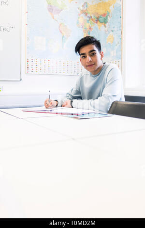 Uno studente internazionale studi hard in una classe in un College di Cambridge Foto Stock