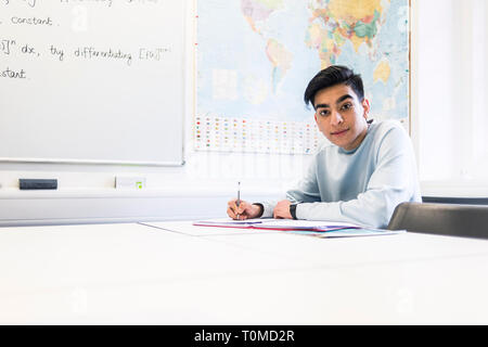 Uno studente internazionale studi hard in una classe in un College di Cambridge Foto Stock