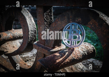 Gancio di plastica moneta di bit sul rubare rustico recinzione arrugginita rampa. Foto Stock
