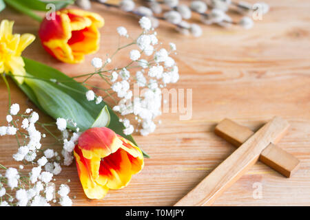 Molla di fiori di pasqua e la croce su sfondo di legno Foto Stock