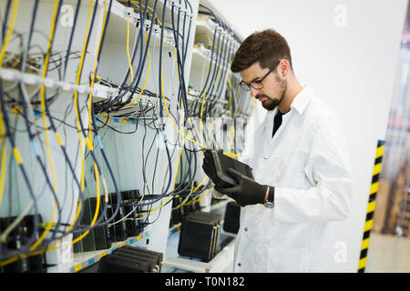 Immagine del tecnico di rete modem di collaudo in fabbrica Foto Stock