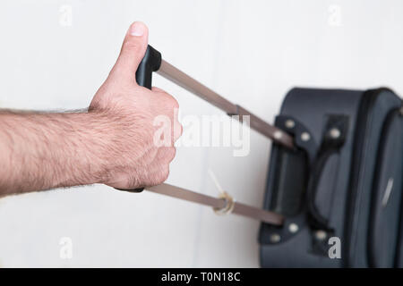 L'uomo tirando i bagagli in un aeroporto Foto Stock