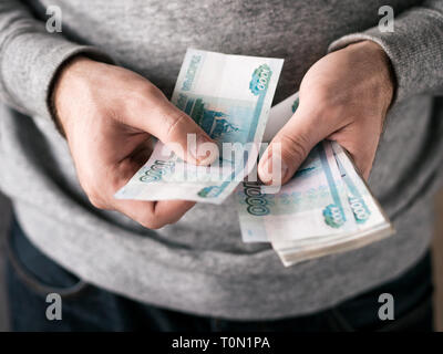 Le mani di conteggio di rubli russi. Messa a fuoco selettiva. DOF poco profondo Foto Stock