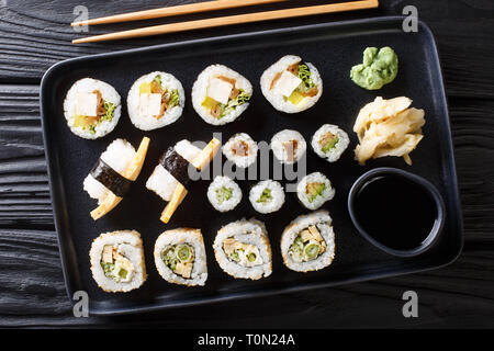 Delizioso sushi giapponese rotoli set di grandi dimensioni con frutti di mare, verdure, tofu e tamago closeup su una piastra sul tavolo. parte superiore orizzontale vista da sopra Foto Stock
