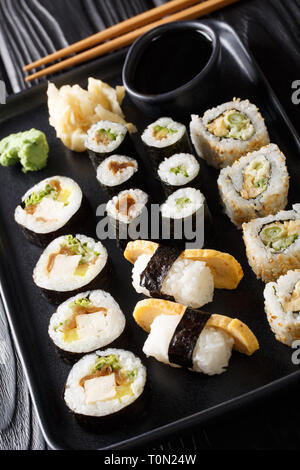 Set di rulli giapponese sushi, Hosomaki Uramaki, maki e nigiri, Tamagoyaki servito con zenzero, wasabi e salsa di soia close-up su una piastra sul tavolo. hor Foto Stock