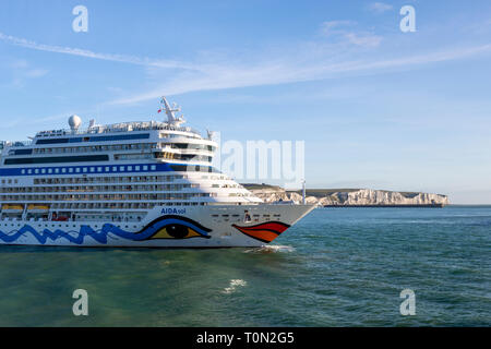 Aidasol nave da crociera ormeggio nel porto di Dover; con la mitica Bianche Scogliere in background. Foto Stock