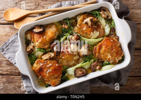 Cotto al forno cosce di pollo con baby bok choi, formaggio e funghi vicino sul tavolo. parte superiore orizzontale vista da sopra Foto Stock