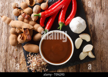 Asian preparata di fresco e salsa di tamarindo con ingredienti di close-up su di un tavolo di legno. parte superiore orizzontale vista da sopra Foto Stock