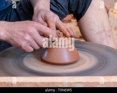 Potter nel suo workshop getta un vaso sul tornio del vasaio in Jianshui, Honghe prefettura, nella provincia dello Yunnan in Cina. Foto Stock