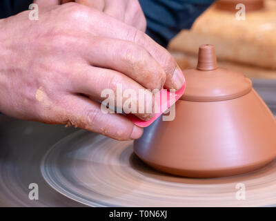 Potter nel suo workshop getta un vaso sul tornio del vasaio in Jianshui, Honghe prefettura, nella provincia dello Yunnan in Cina. Foto Stock