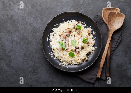 Delizioso risotto ai funghi conditi con formaggio parmigiano e prezzemolo. Vista da sopra con lo spazio di copia Foto Stock